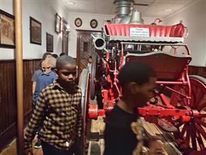 students standing around an old fire engine